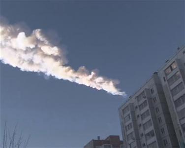 Still image from video shows the trail of a falling object above a residential apartment block in the Urals city of Chelyabinsk